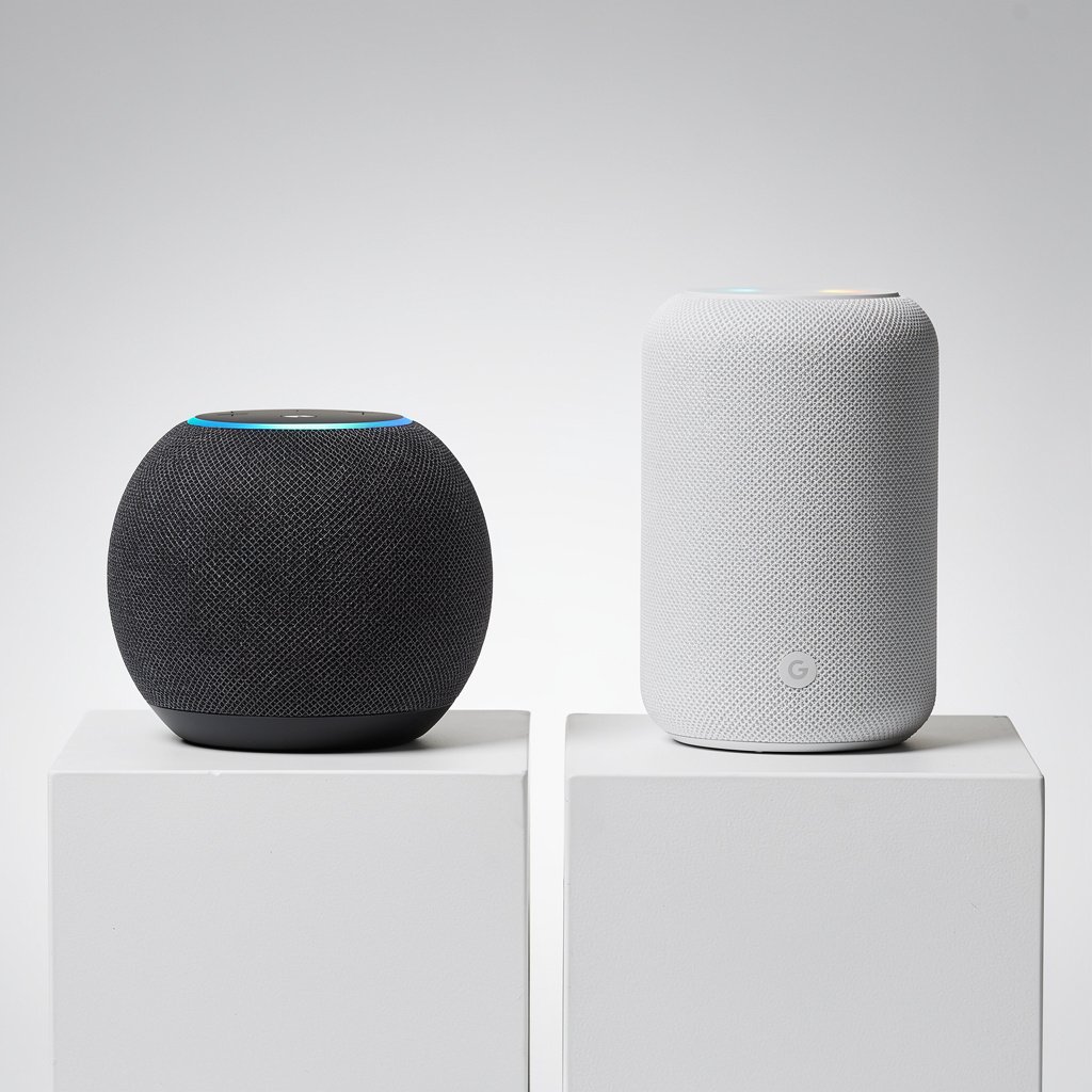 Amazon Echo and Google Nest Audio side by side comparison on neutral background
